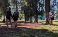 three women playing disc golf and smiling