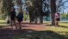 three women playing disc golf and smiling